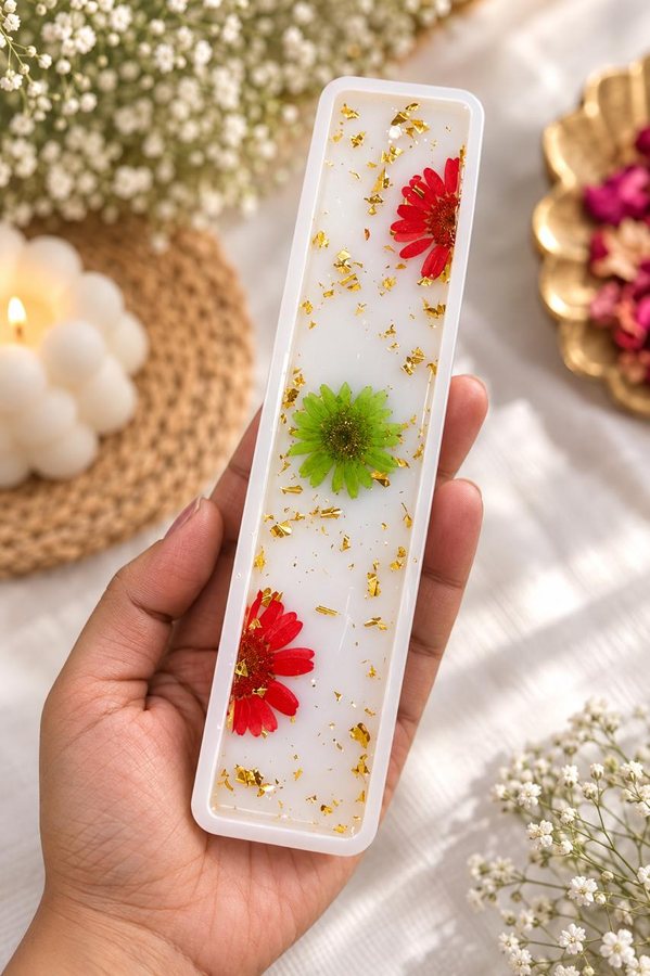 White resin bookmark with red and green dried flowers