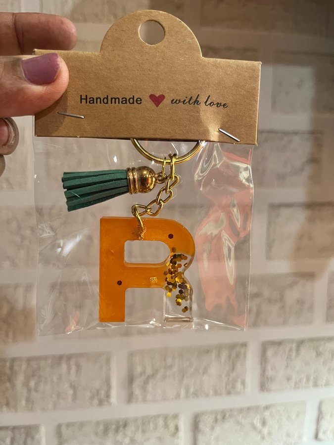 Orange glitter R keyring with green tassel